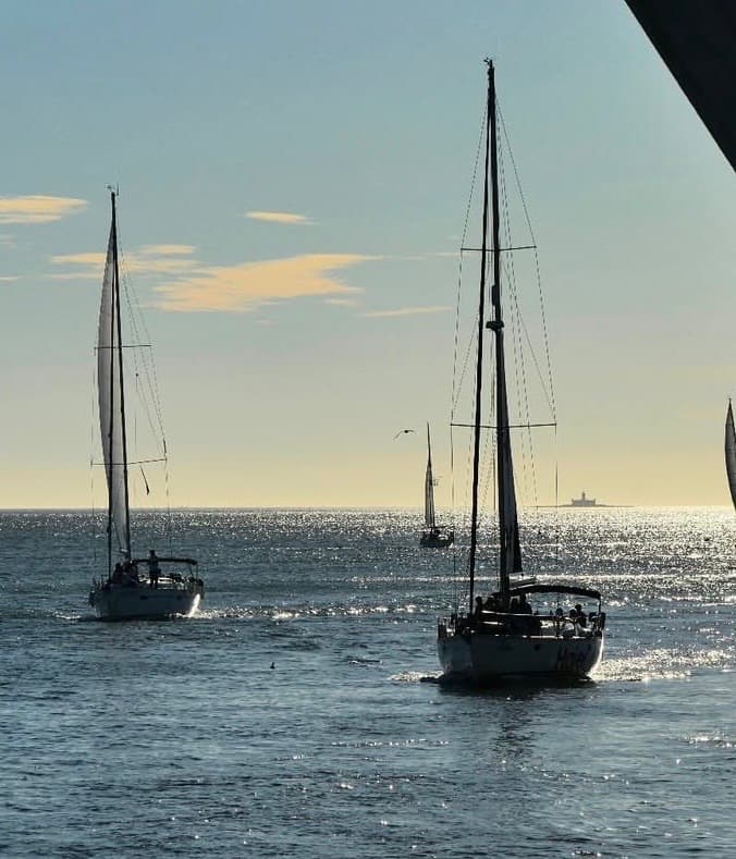 Voiliers sur une mer scintillante au crépuscule